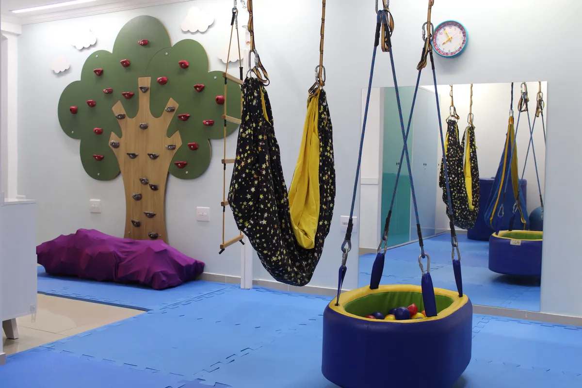Sala de Terapia Ocupacional ampla e acolhedora com tatames e brinquedos pedagógicos